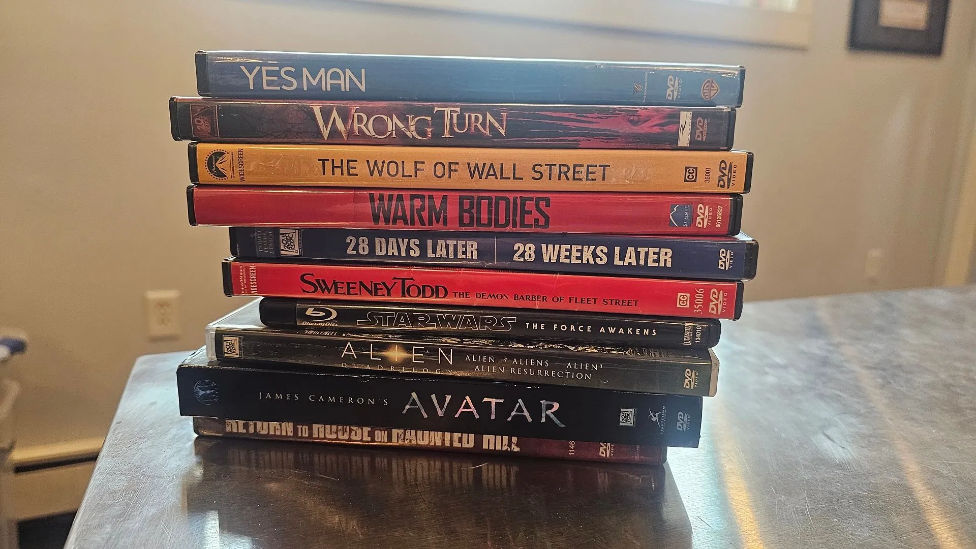 Bộ sưu tập đĩa DVD và Blu-ray đã qua sử dụng trên bàn kim loại