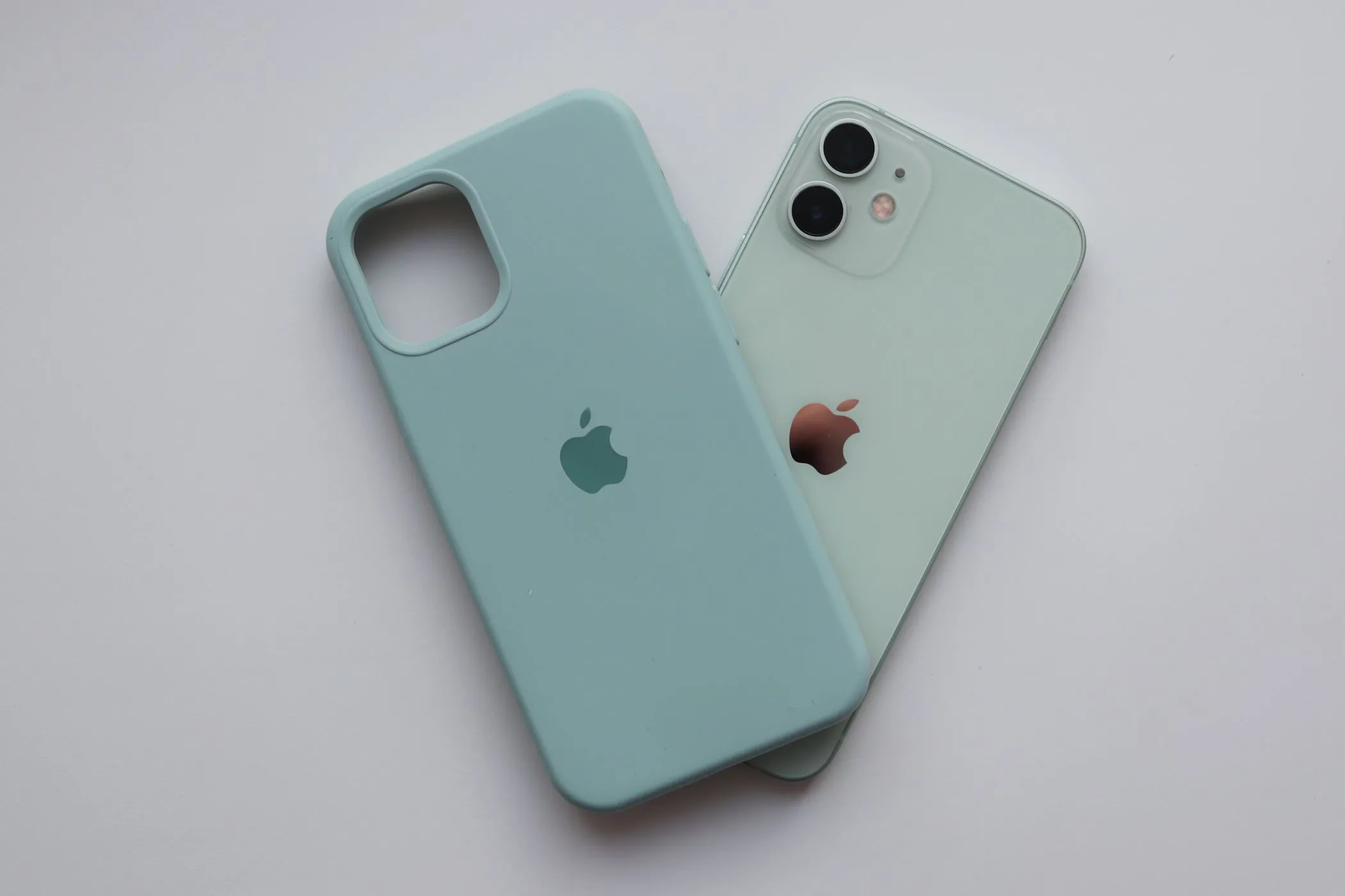 Điện thoại iPhone 12 màu xanh bạc hà và ốp lưng Apple Silicone, biểu tượng cho việc tối ưu thiết bị công nghệ cũ.