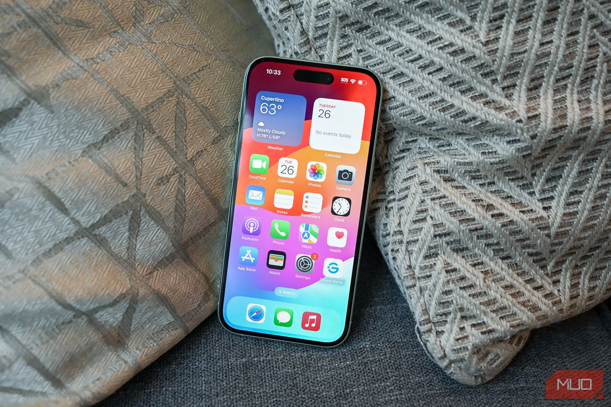 Người dùng đang tương tác với màn hình chính trên iPhone 15, biểu tượng ứng dụng và widget được hiển thị rõ ràng