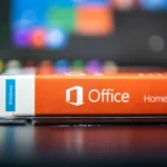 Người dùng đang xem xét hộp đựng phần mềm Microsoft Office Home and Student phiên bản vật lý trên bàn làm việc