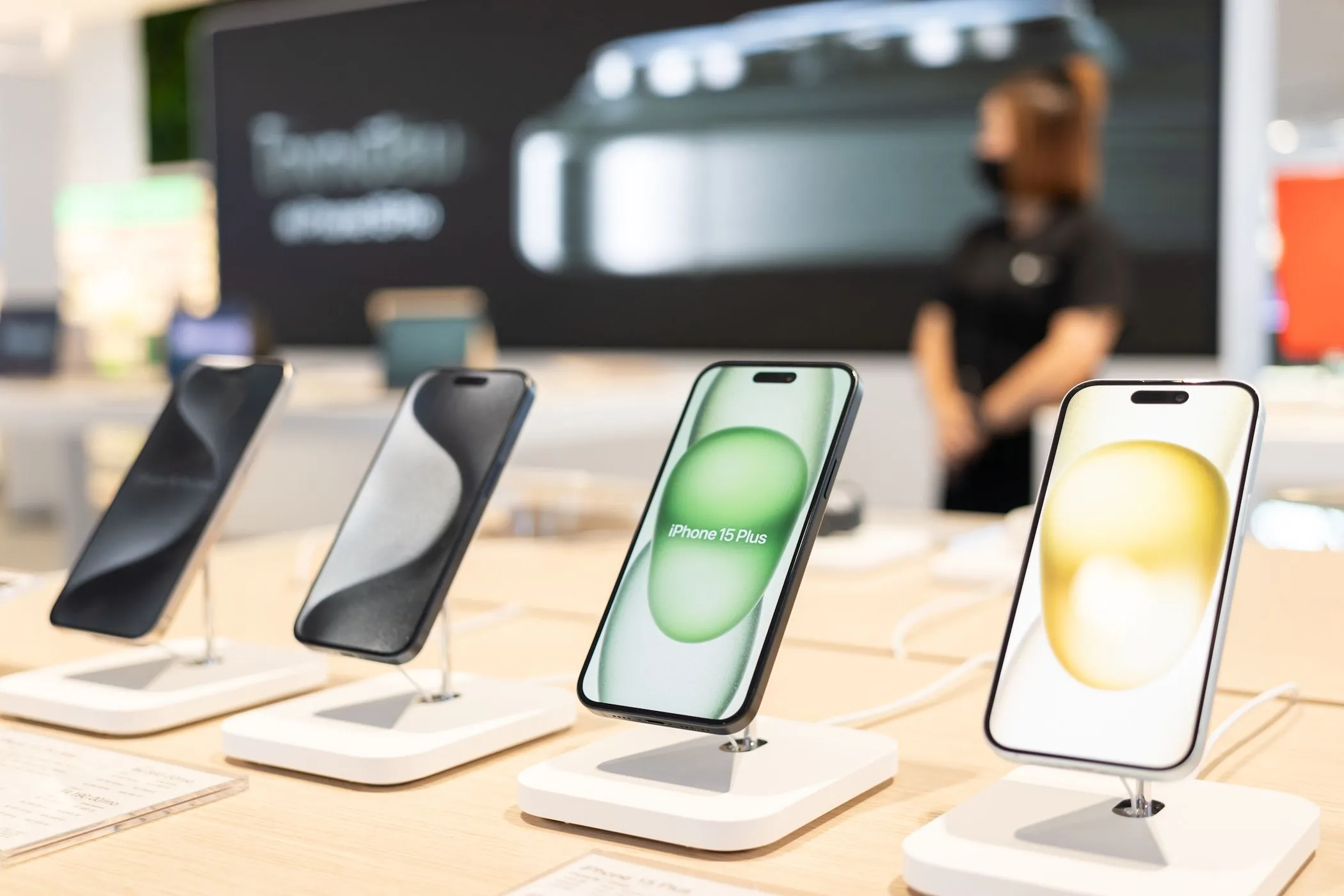 Các mẫu iPhone 15 mới đang được trưng bày tại cửa hàng Apple, đối lập với việc lựa chọn giữ lại các mẫu điện thoại cũ như iPhone 11 để giảm thiểu tác động môi trường.