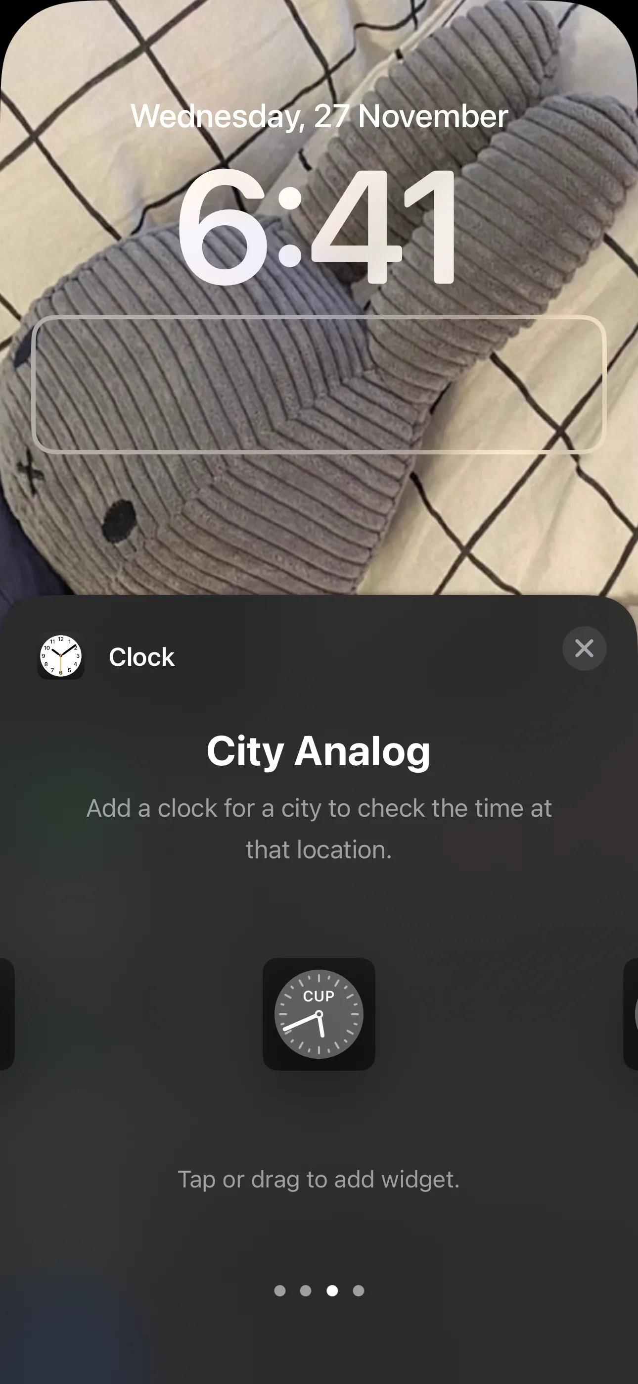 Các tùy chọn widget đồng hồ trên Màn hình khóa iPhone, bao gồm Đồng hồ Số Thành phố, Đồng hồ Kim Thành phố và Đồng hồ Thế giới.