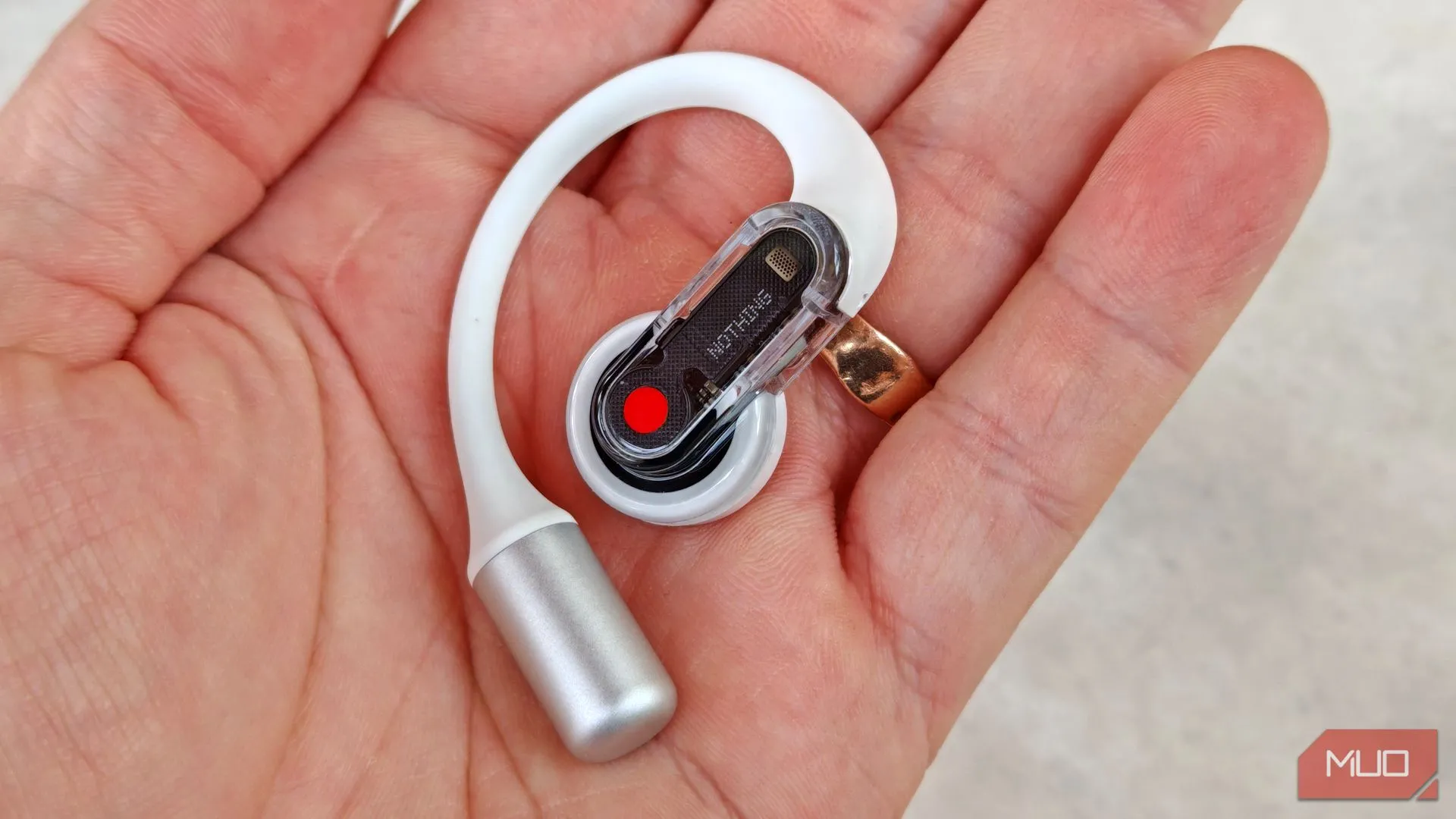 Cận cảnh tai nghe Nothing Ear (open) bên phải được cầm trên tay, hiển thị vị trí nút điều khiển