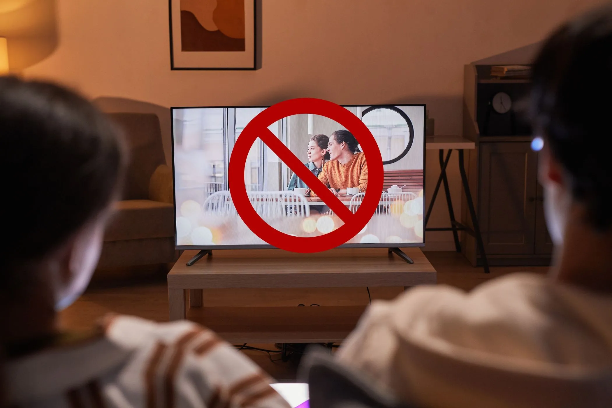 Cặp đôi xem TV với biểu tượng cấm trên màn hình, minh họa việc từ chối các khuyến nghị AI và bảo vệ quyền riêng tư trên TV thông minh