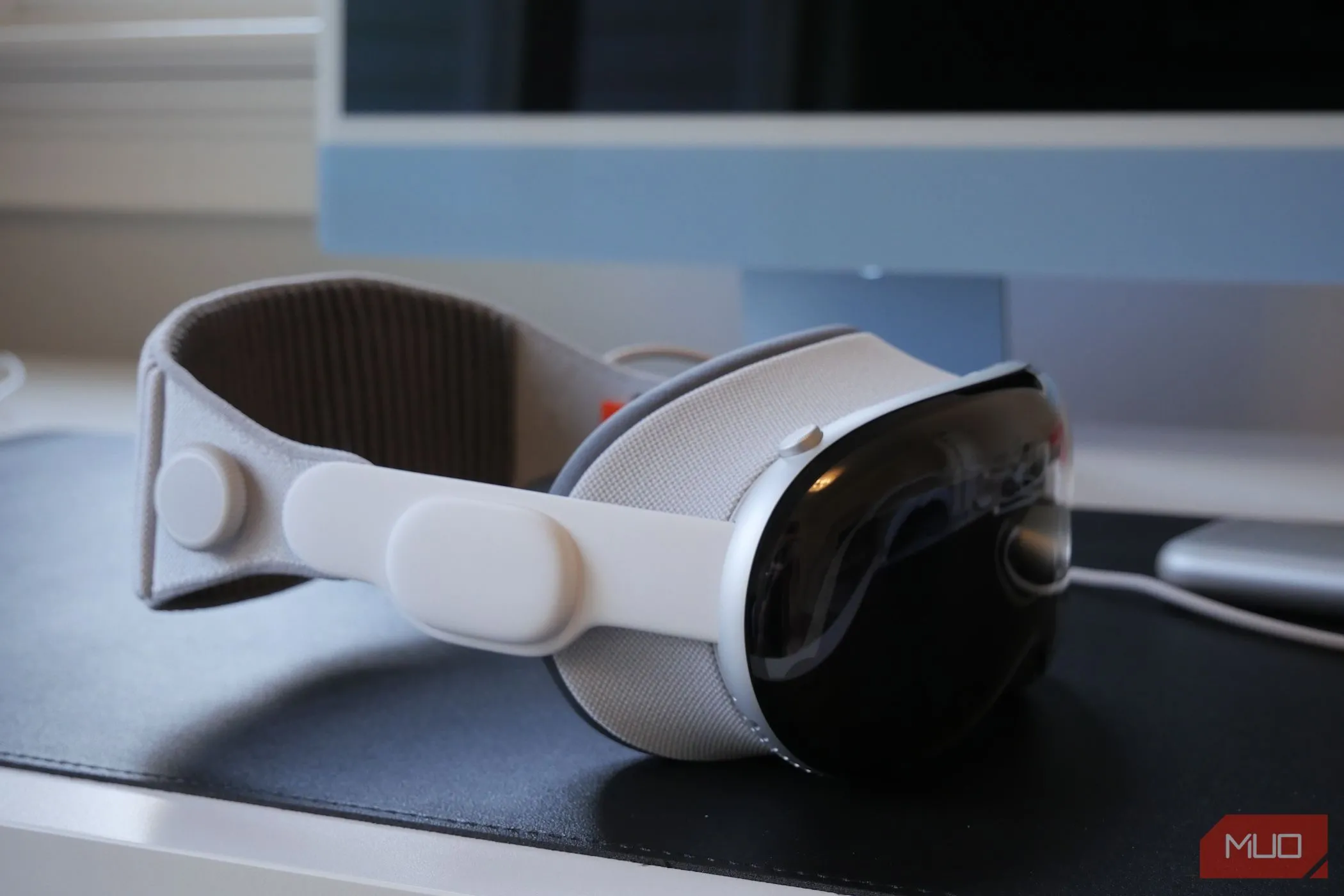 Chiếc kính thực tế tăng cường Apple Vision Pro đặt trên bàn, tượng trưng cho tiềm năng tạo không gian làm việc ảo khi kết nối với iPhone.