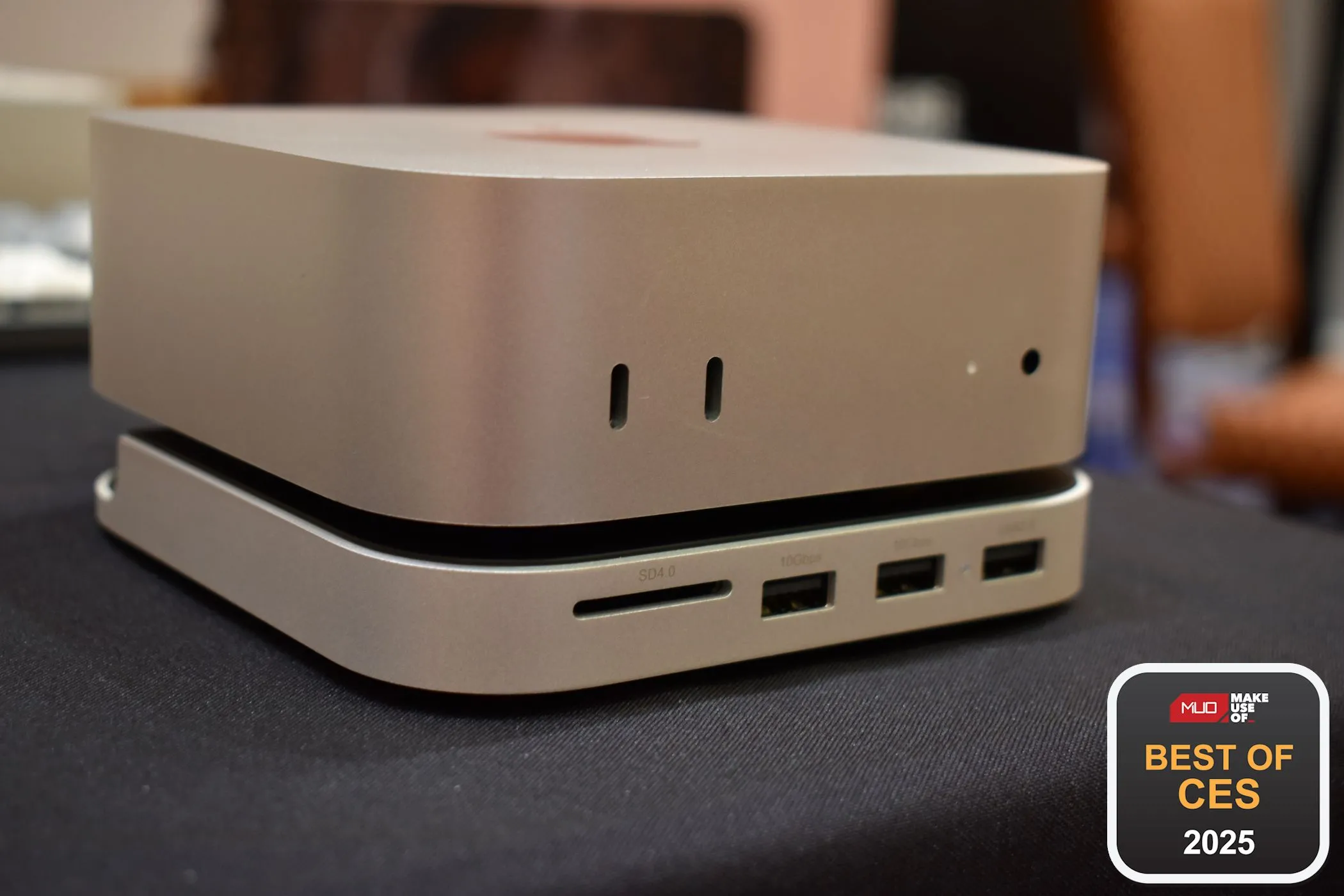 Đế đứng kiêm hub kết nối Satechi màu bạc cho Mac Mini M4, đặt cạnh Mac Mini, làm tăng cổng kết nối và lưu trữ.