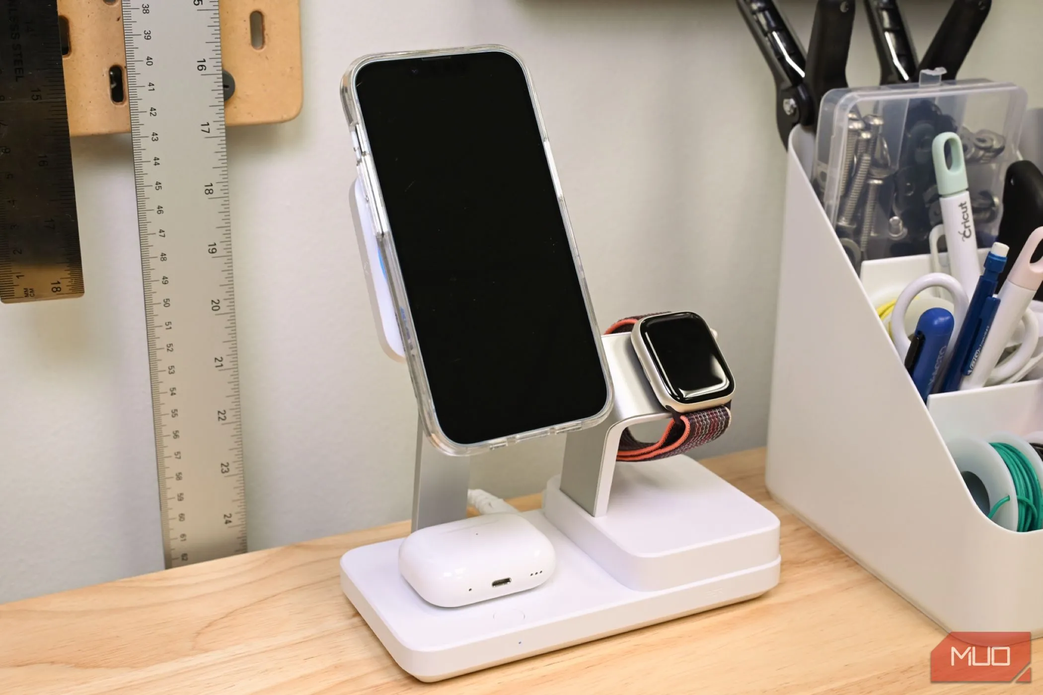 Điện thoại iPhone, tai nghe AirPods và đồng hồ Apple Watch đang sạc trên đế sạc đa năng Qi2 ESR