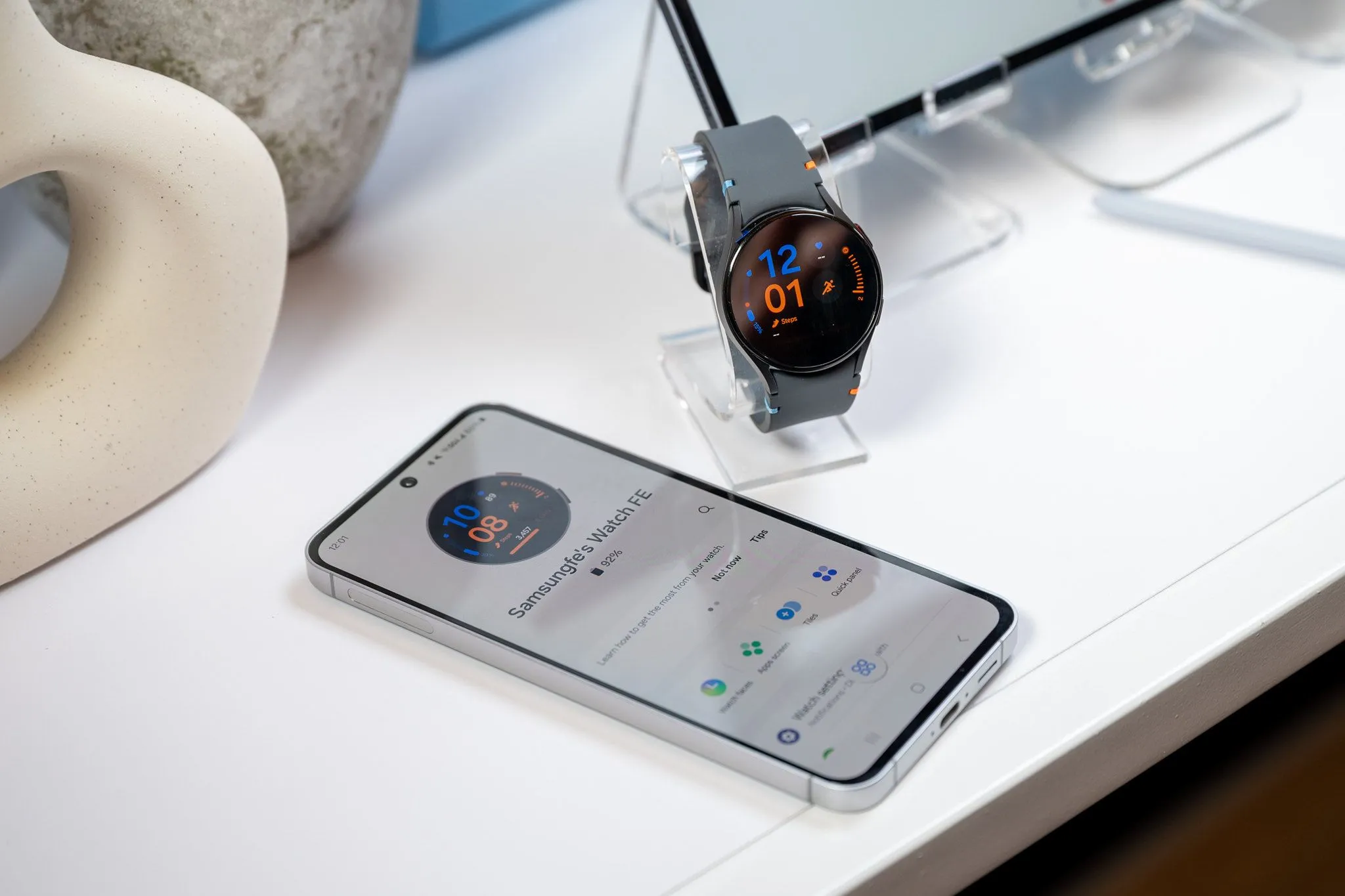Điện thoại Samsung Galaxy S24 FE đang sạc pin cho Galaxy Watch LTE qua cáp USB-C, minh họa khả năng sạc dự phòng của điện thoại.