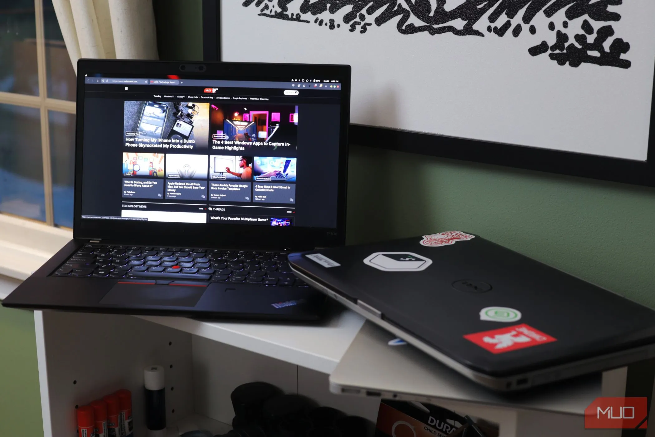 Hai chiếc laptop đặt trên kệ trắng, một chiếc đang mở, minh họa việc chia sẻ thiết bị có thể làm lộ thông tin nhạy cảm và mật khẩu đã lưu trên trình duyệt.