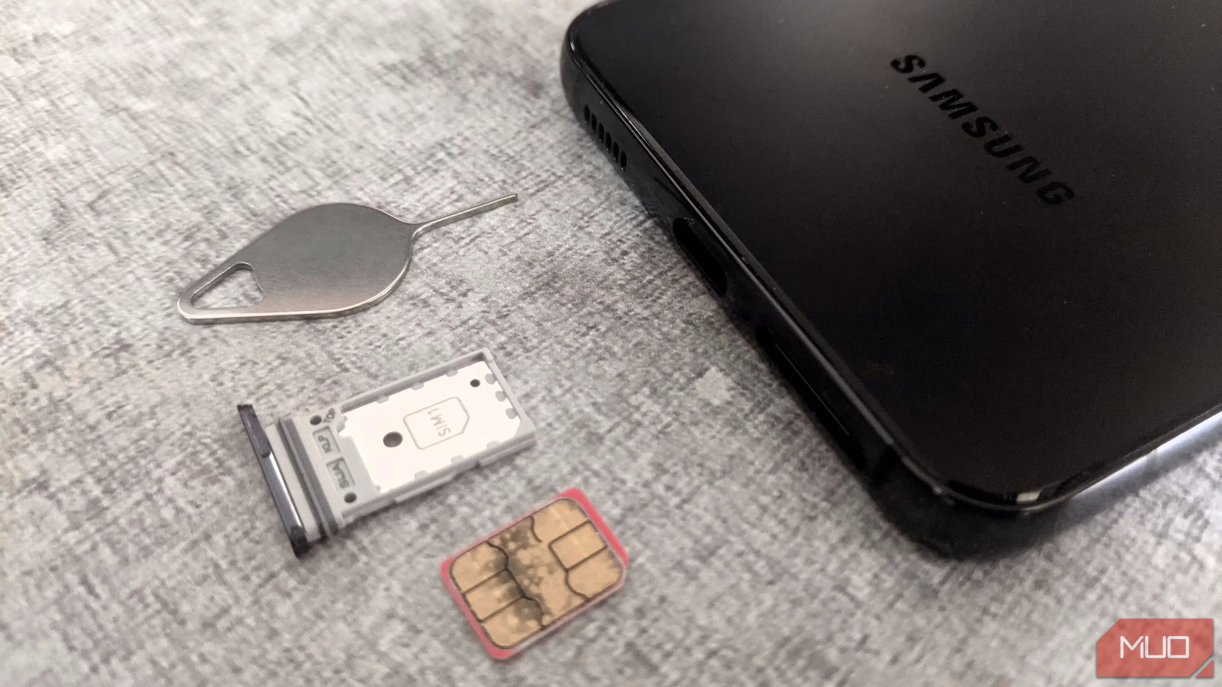 Khay SIM điện thoại Samsung và công cụ tháo SIM, minh họa nguy cơ tấn công hoán đổi SIM trong bảo mật điện thoại di động.