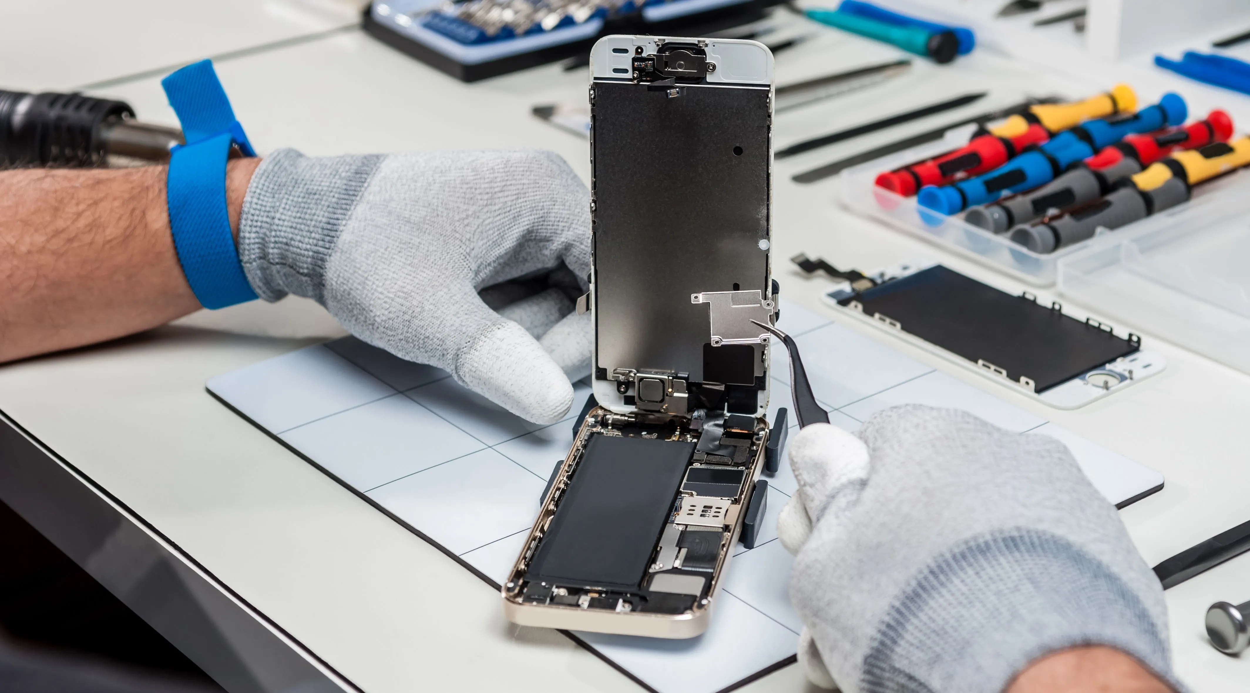 Kỹ thuật viên đang kiểm tra và thay thế pin smartphone, minh họa quá trình sửa chữa điện thoại giúp kéo dài tuổi thọ thiết bị