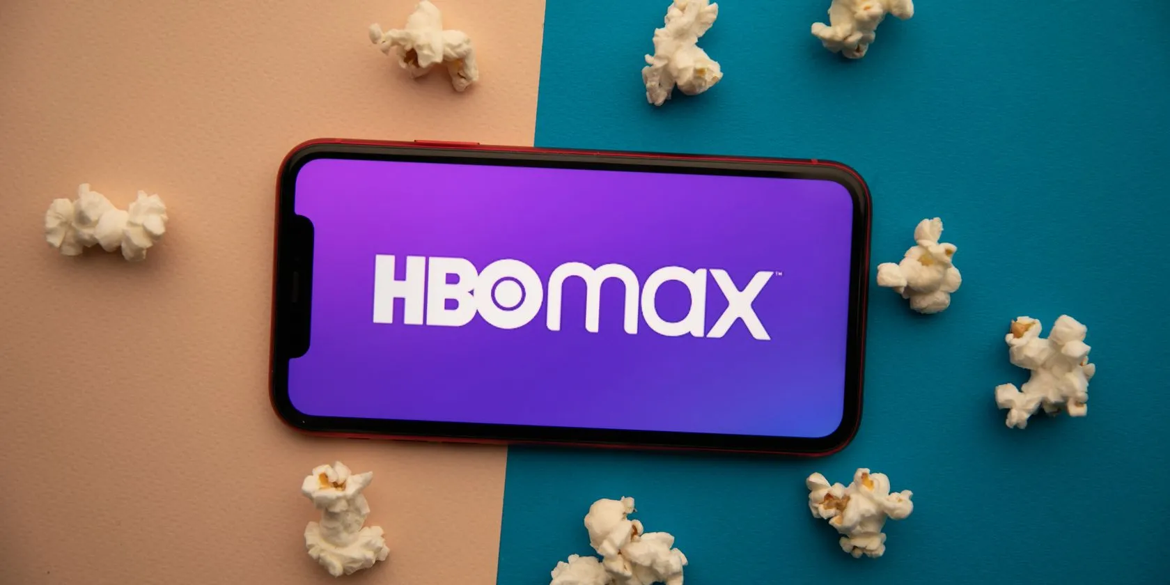 Logo HBO Max hiển thị trên màn hình điện thoại, với hình ảnh bỏng ngô và không gian giải trí phía sau, gợi ý trải nghiệm xem phim thoải mái