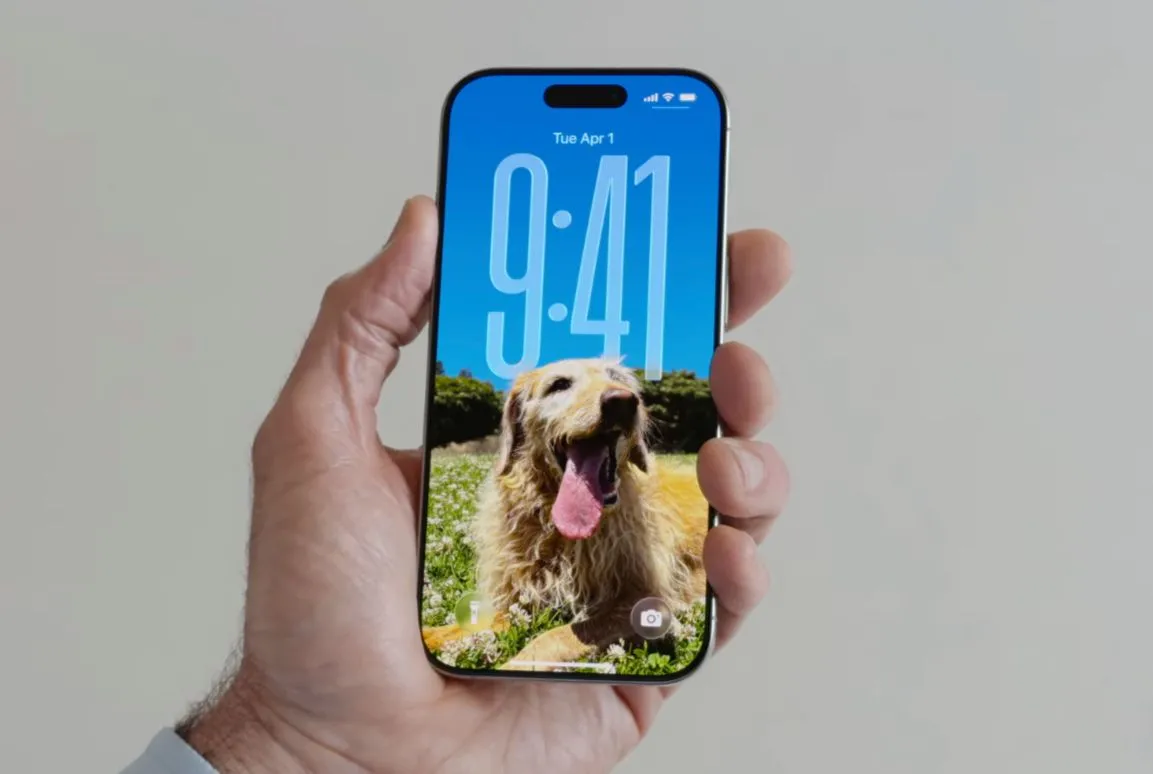Màn hình khóa iPhone chạy iOS 26 hiển thị đồng hồ lớn và các widget được tùy chỉnh vị trí bên dưới