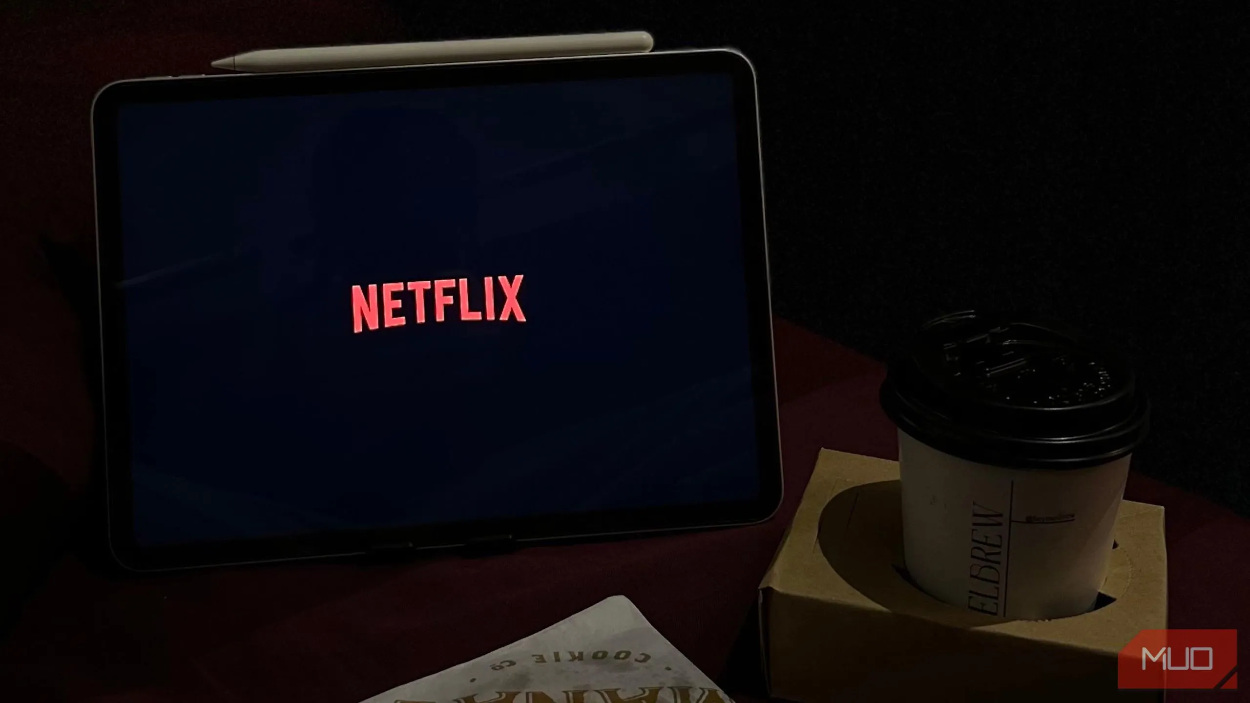 Màn hình Netflix trên iPad bên cạnh cốc cà phê, thể hiện việc sử dụng thiết bị trước khi ngủ.