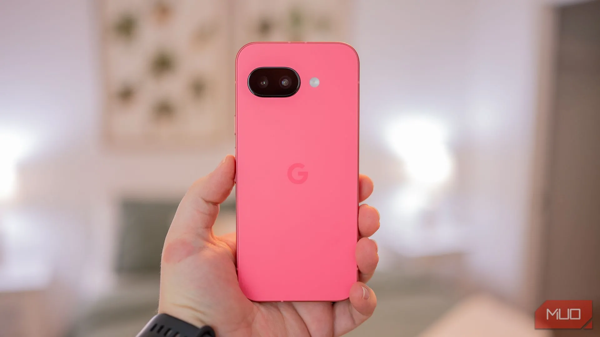 Một người đang cầm Google Pixel 9a, hiển thị mặt lưng với thiết kế tối giản và màu sắc tinh tế