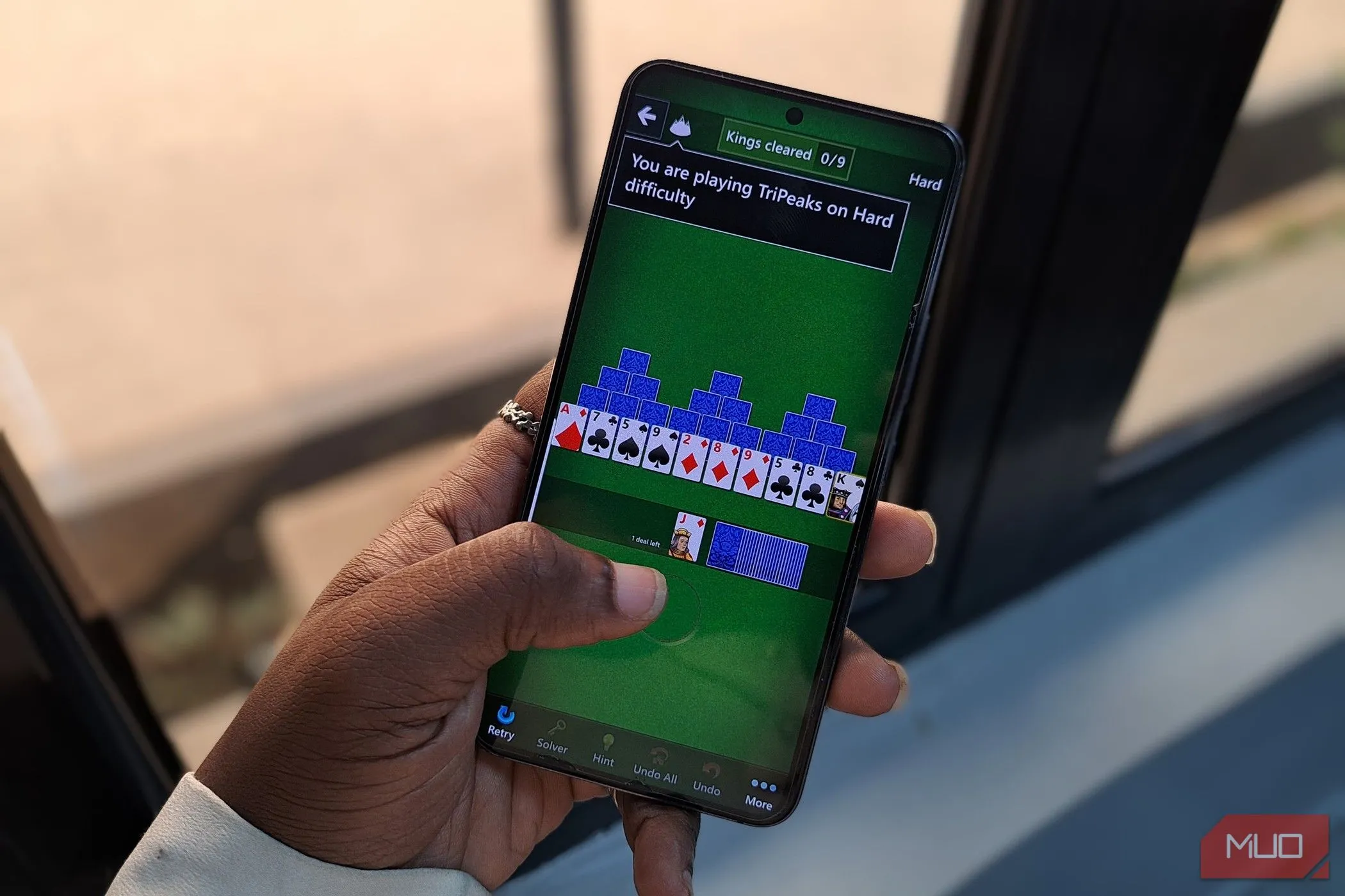 Một người đang chơi game Microsoft Solitaire trên màn hình điện thoại di động