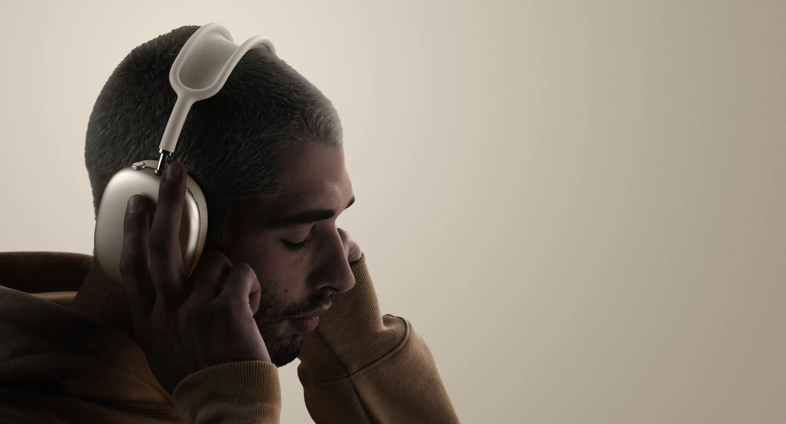 Một người đang đeo tai nghe AirPods Max, thể hiện kích thước và trọng lượng có thể gây mỏi khi sử dụng lâu
