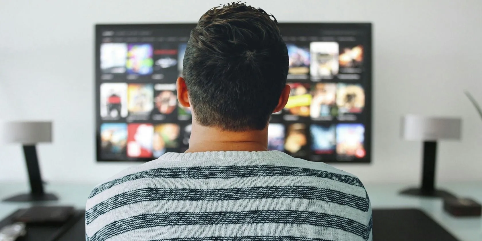 Người đàn ông đang xem nhiều dịch vụ streaming khác nhau trên TV