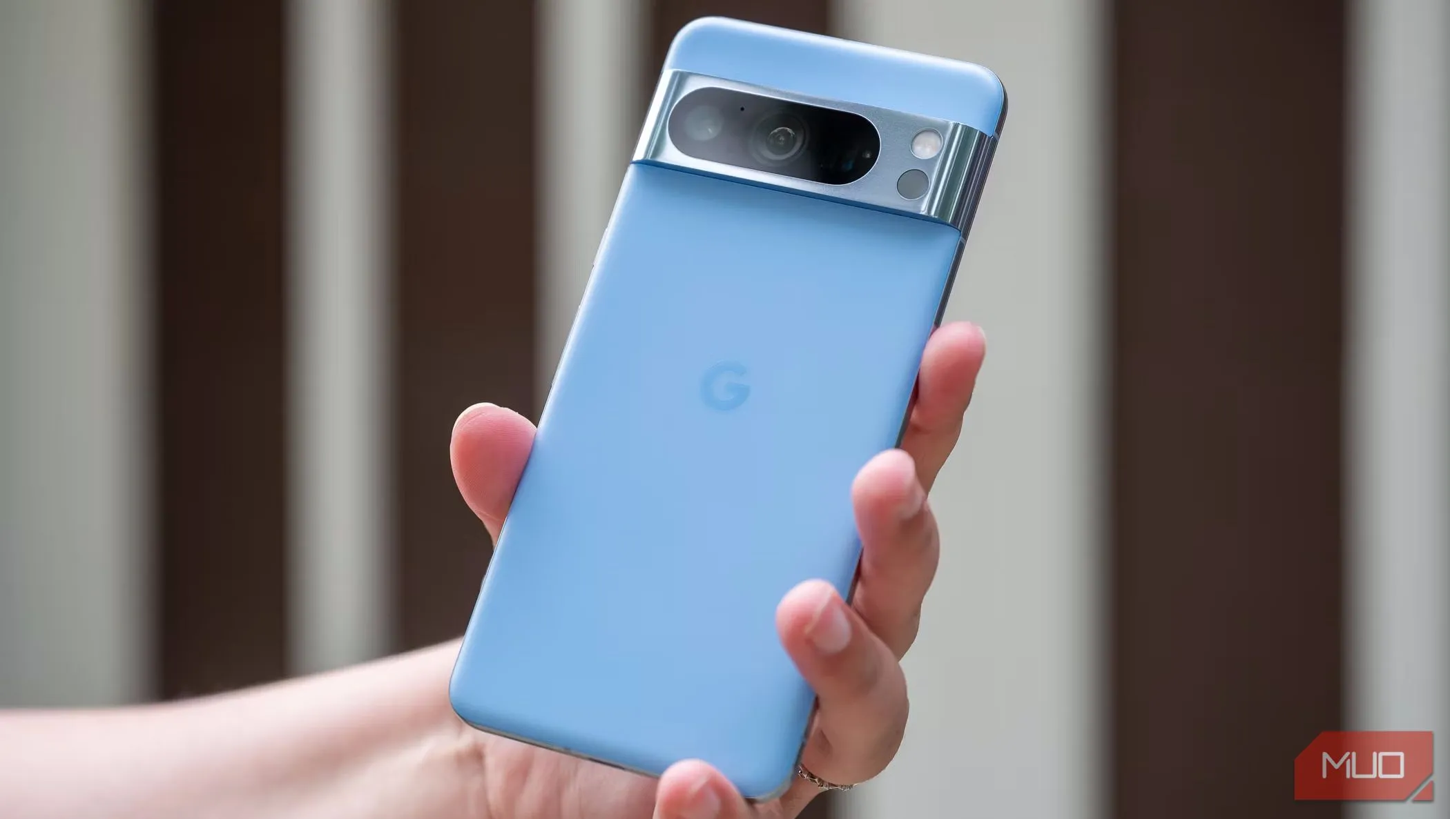 Người dùng cầm điện thoại Google Pixel 8 Pro màu đen ở mặt lưng