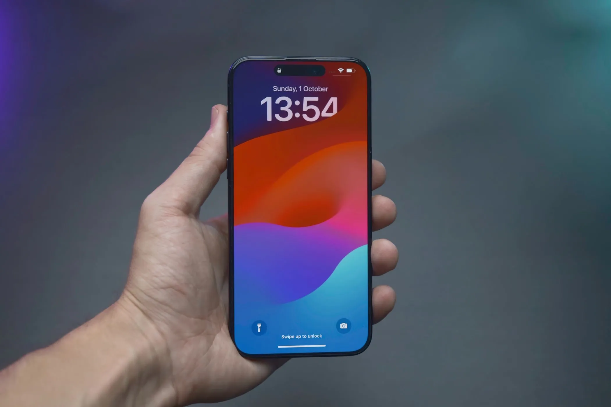Người dùng cầm iPhone 14 Pro hiển thị thời gian, minh họa việc sử dụng Phím tắt Trợ năng để tối ưu trải nghiệm
