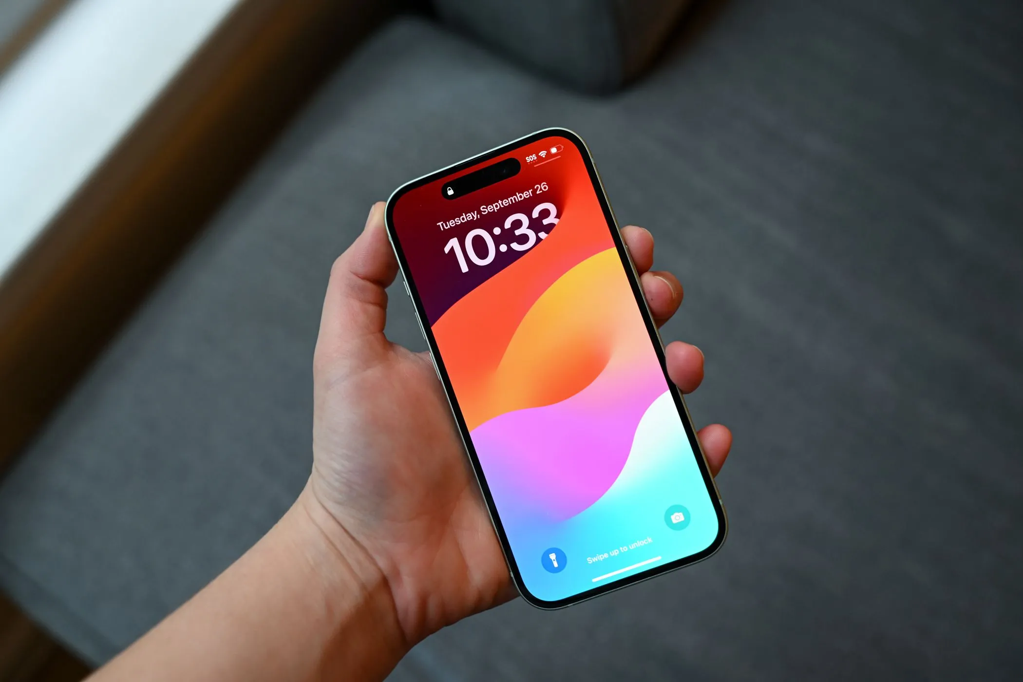 Người dùng cầm iPhone 15 với màn hình được che giấu vết xước