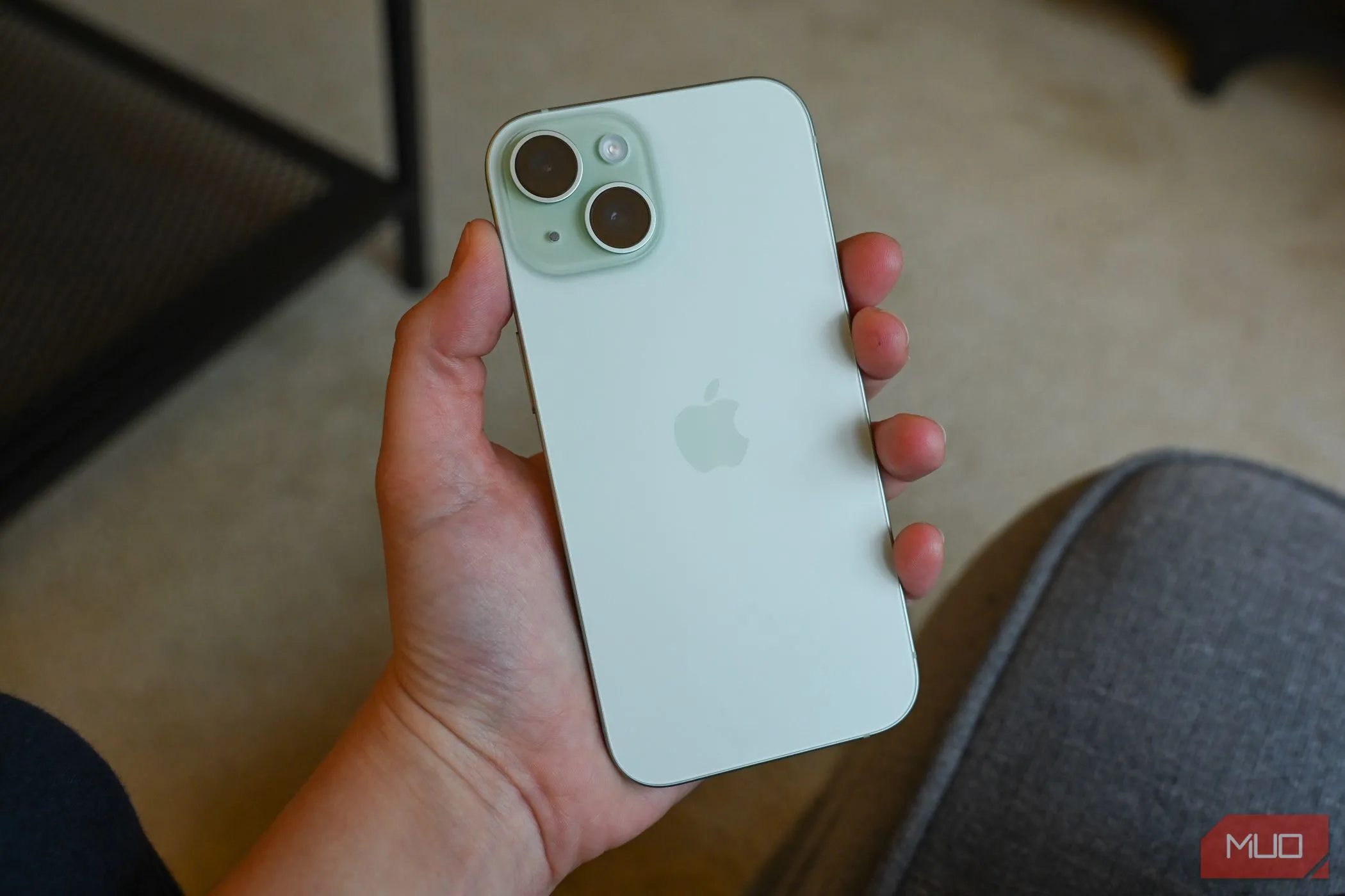 Người dùng đang cầm chiếc iPhone 15 màu xanh dương trên tay, thể hiện thiết kế cao cấp và màn hình tràn viền