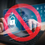 Người dùng đang gõ phím trên laptop với biểu tượng cấm đỏ che phủ các icon bảo mật, minh họa rủi ro tiện ích mở rộng trình duyệt độc hại có thể đánh cắp dữ liệu mật khẩu.