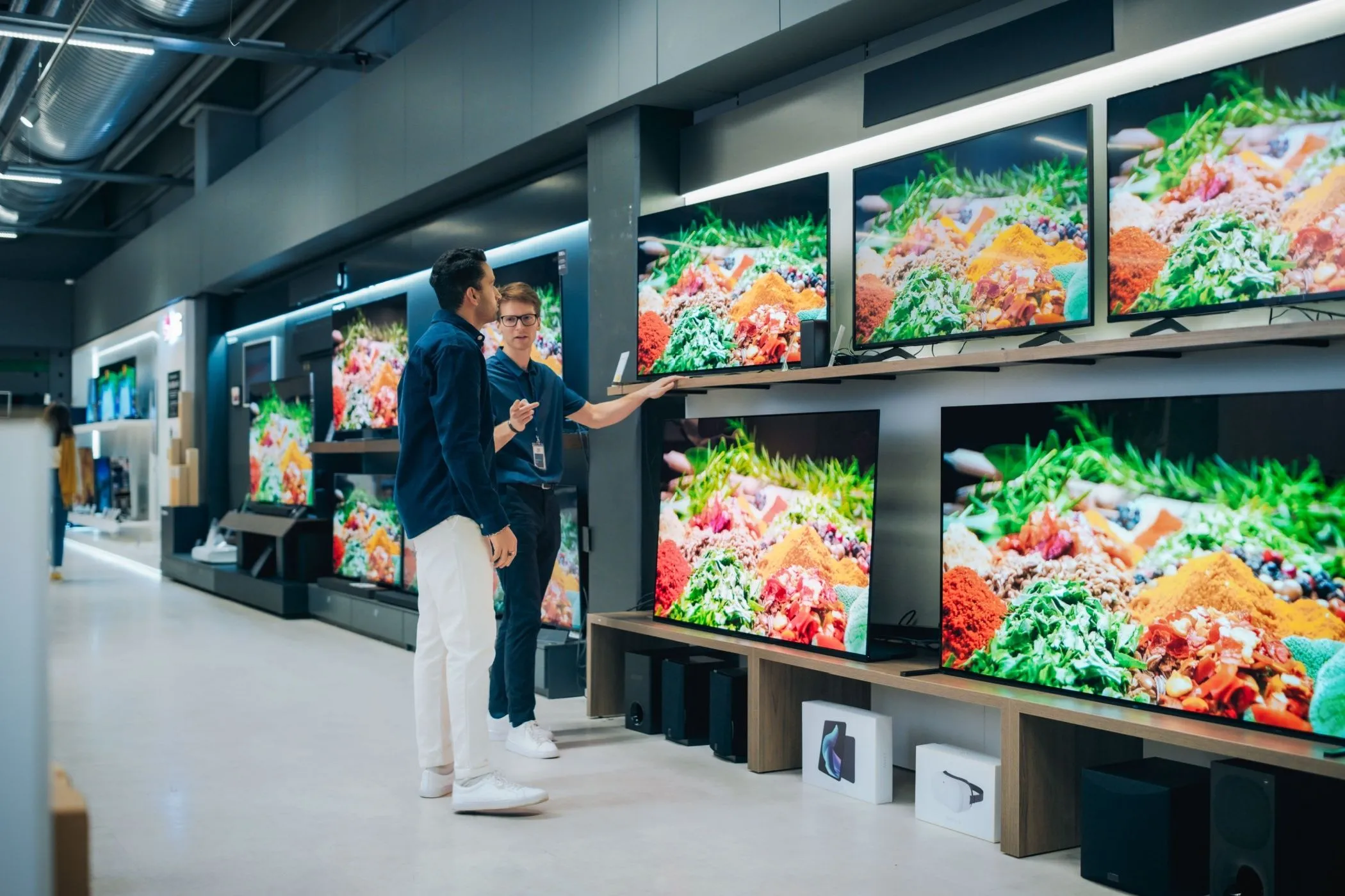 Nhân viên cửa hàng tư vấn tivi cho khách hàng