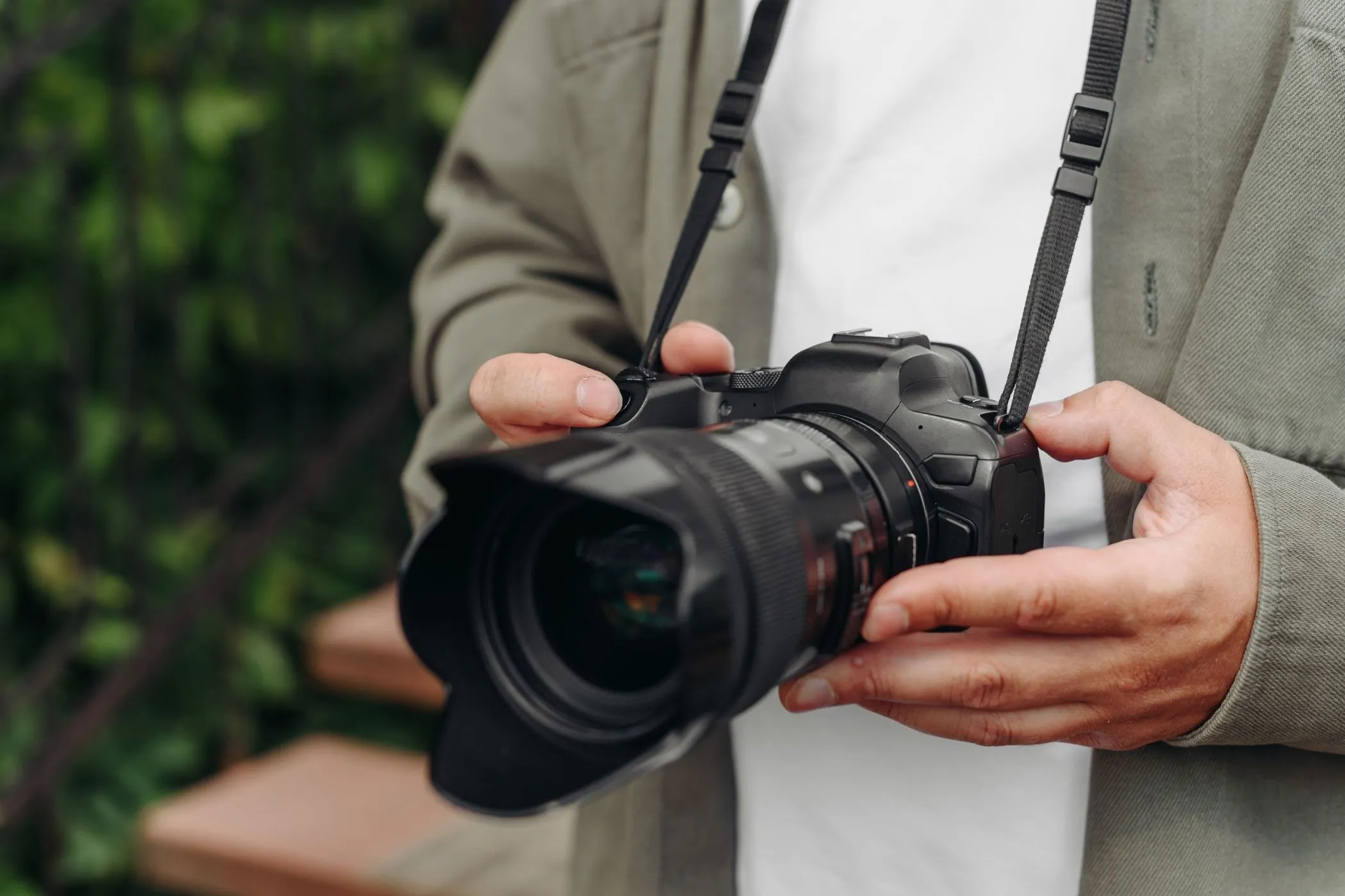 Nhiếp ảnh gia trẻ tuổi cầm chắc máy ảnh DSLR, thể hiện sự bền bỉ và dễ thao tác trong các điều kiện chụp khác nhau