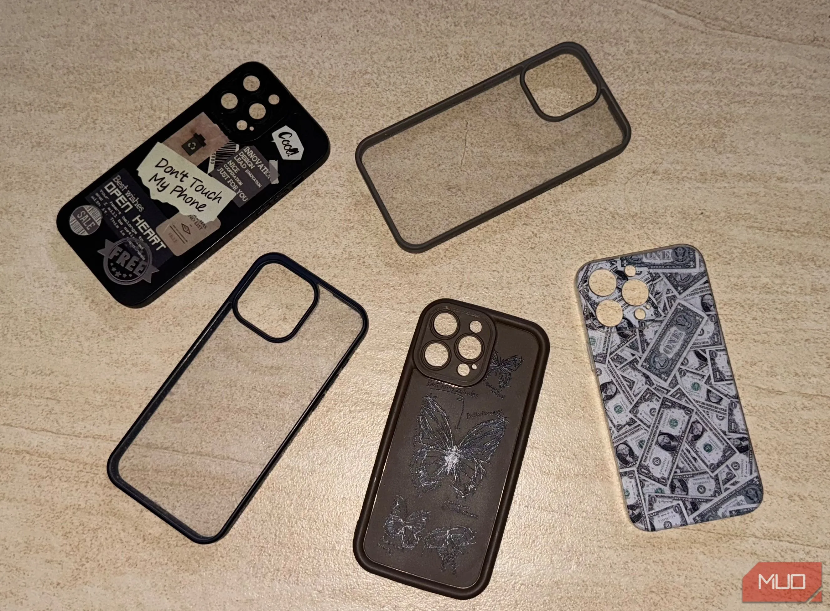 Nhiều mẫu ốp lưng điện thoại iPhone 15 Pro Max đặt trên sàn, thể hiện sự cần thiết của ốp lưng và ảnh hưởng đến độ dày tổng thể