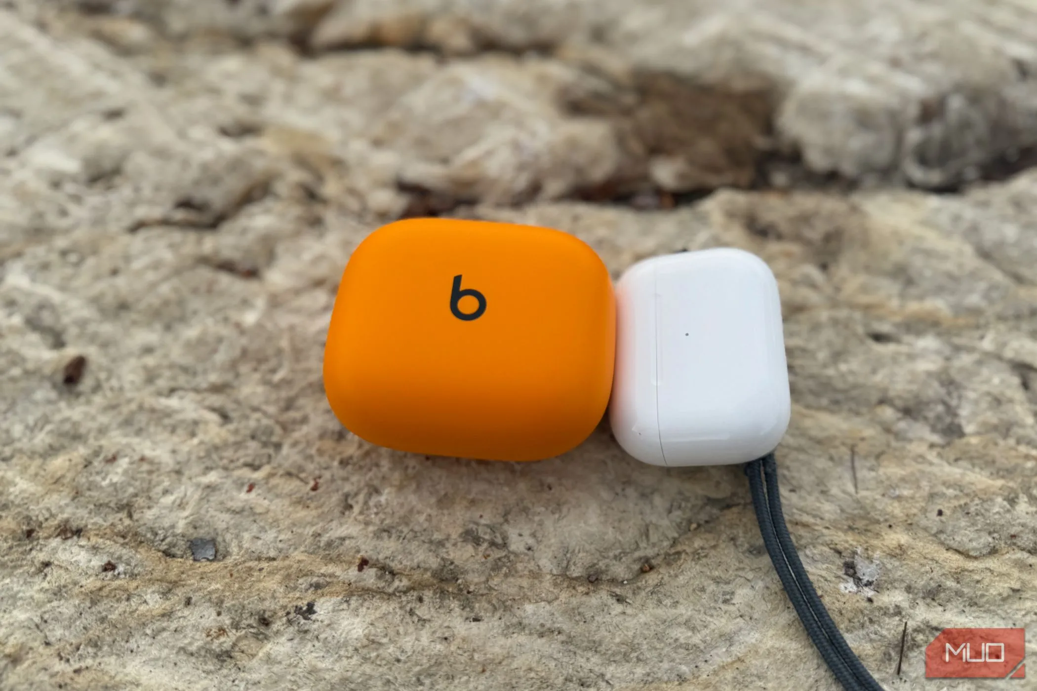 So sánh kích thước hộp sạc của Powerbeats Pro 2 và AirPods Pro 2, làm nổi bật sự cồng kềnh của hộp sạc Powerbeats Pro 2.