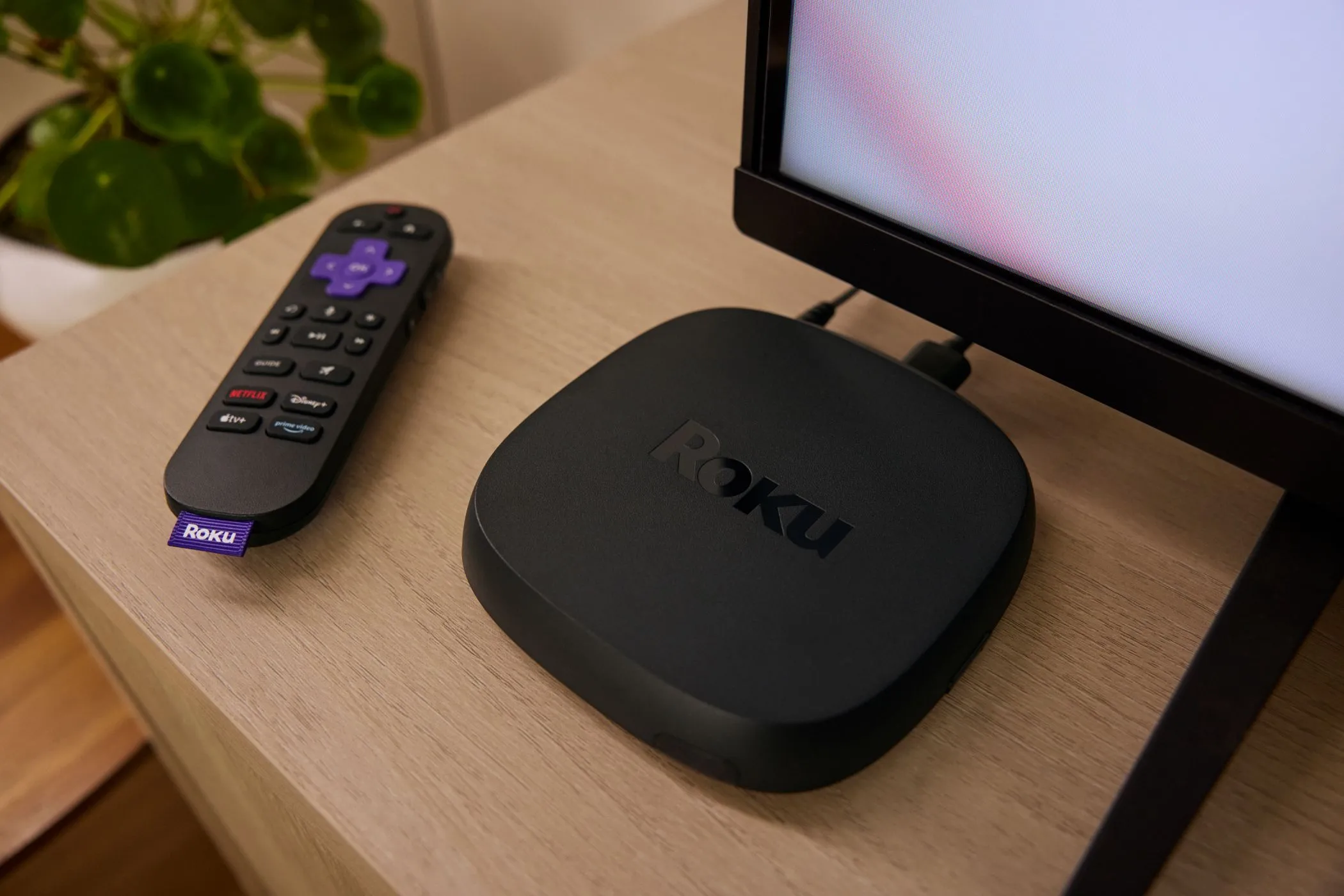 Thiết bị streaming Roku Ultra phiên bản 2024 và điều khiển từ xa đặt cạnh TV, biểu tượng cho giải pháp biến TV thường thành TV thông minh.