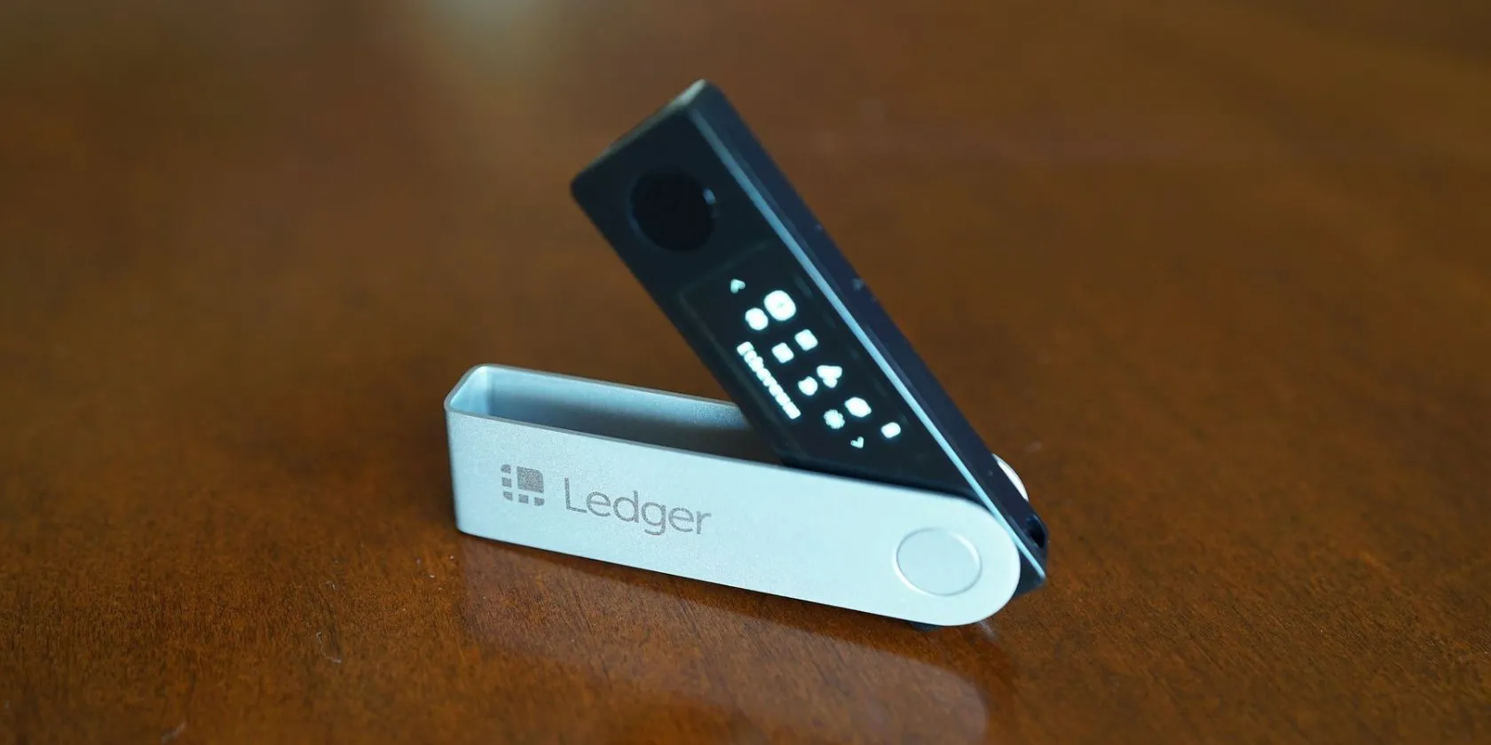 Ví lạnh Ledger Nano X màu đen trên bề mặt gỗ